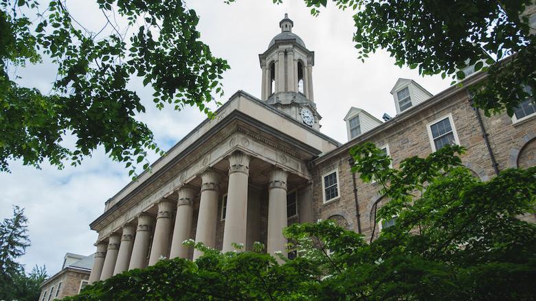 Photograph of Old Main surrounded by summer foliage